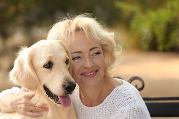 Wall Mural - Senior woman sitting on bench with dog, closeup