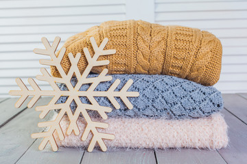 Wall Mural - Stack of white cozy knitted sweaters on a wooden table