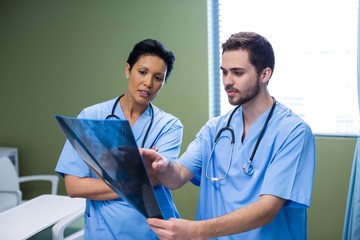 Wall Mural - Male and female nurse discussing x-ray in ward