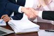 © rogerphoto - Business people shaking hands finishing up a meeting