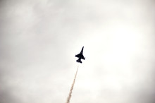 Low Angle View Of Military Airplane Flying In Cloudy Sky