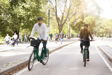Happy Couple Riding Bicycle In Park