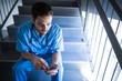 © WavebreakMediaMicro - Male nurse sitting on staircase and using mobile phone