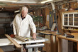 © Cavan Images - Carpenter measuring plank in workshop