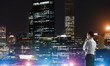 © adam121 - Businessman viewing night glowing city