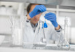 © guruXOX - Male laboratory researcher performs tests with blue liquid