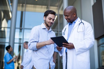 Doctor and patient having discussion on digital tablet