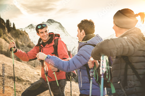 Zdjęcie XXL Grupa przyjaciół trekking na francuskich Alpach o zachodzie słońca - Piesi z plecakami i kije chodzenie na górze - Wanderlust koncepcja podróży z młodych ludzi na wycieczce w dzikiej przyrody - Skup się na lewym facetem