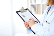 © rogerphoto - Close up of  female doctor  writing a medical prescription at clipboard while standing