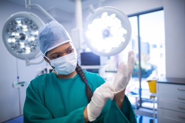 Poster - Surgeon wearing surgical gloves in operation theater