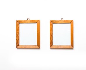 Two wooden frames on white wall.