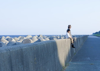 Poster - Father and son sitting on breakwater