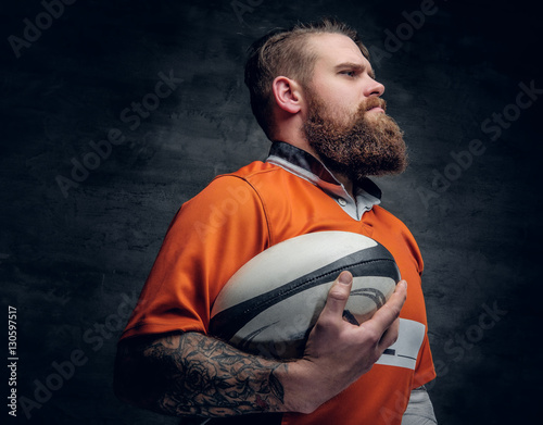 Plakat Brodaty rugby gracz trzyma piłkę do gry.