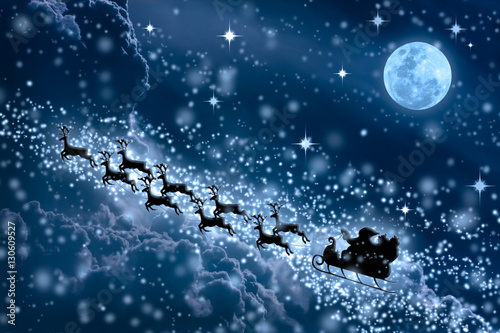 Foto-Schiebegardine mit Schienensystem - Christmas blue background. Silhouette of Santa Claus flying on a sleigh pulled by reindeer.  (von kdshutterman)