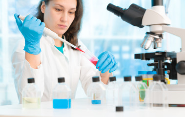 Sticker - Woman technician with multipipette in genetic laboratory PCR research. Student girl use pipette. Young female scientist loads samples for DNA amplification by PCR