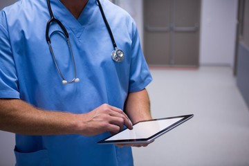 Poster - Surgeon using digital tablet in corridor at hospital