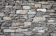 Grey stone wall with different sized stones, modern siding