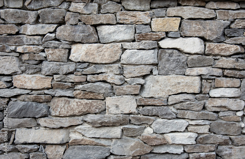 Fotografía Grey stone wall with different sized stones, modern siding