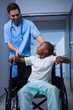 © WavebreakMediaMicro - Male nurse interacting with child patient in corridor