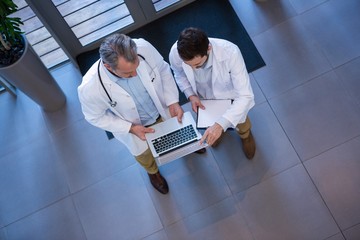 Wall Mural - Doctors using laptop in corridor