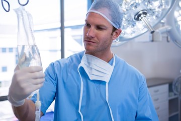 Poster - Male nurse adjusting iv drip in operation theater