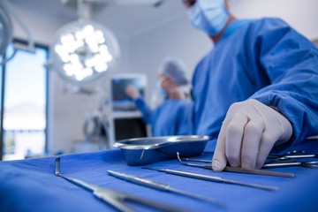 Poster - Surgeon holding surgical tool in operation theater