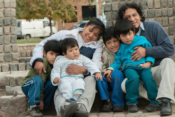 Wall Mural - Happy Latin family sitting in the street