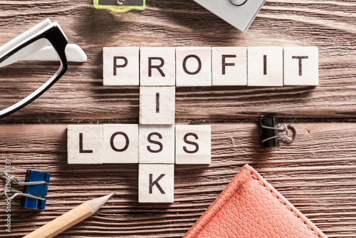 Fotografía Profit loss and risk words on workplace collected of wooden cubes