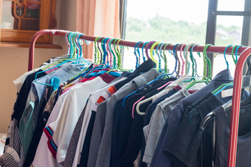 men's and women's dresses on hangers in a house.