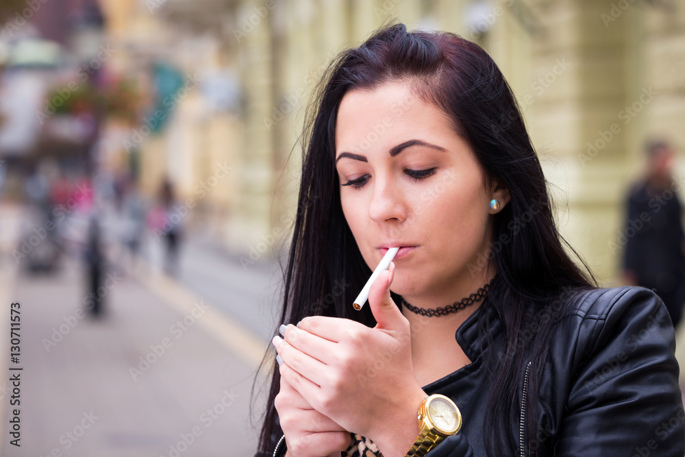 women smoking ultra long cigarettes black long hair young woman smoking cigarette in walking street Stock Photo