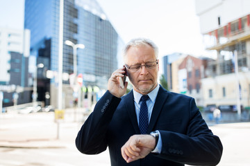 Wall Mural - senior businessman calling on smartphone in city