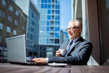 Poster - senior businessman with laptop drinking coffee