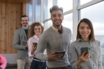 Canvas Print - Businesspeople In Coworking Center Business Team Coworkers Using Tablet Computers Sitting in front Panoramic Window Modern Office