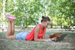 © Africa Studio - Cute young girl with laptop on lawn in park
