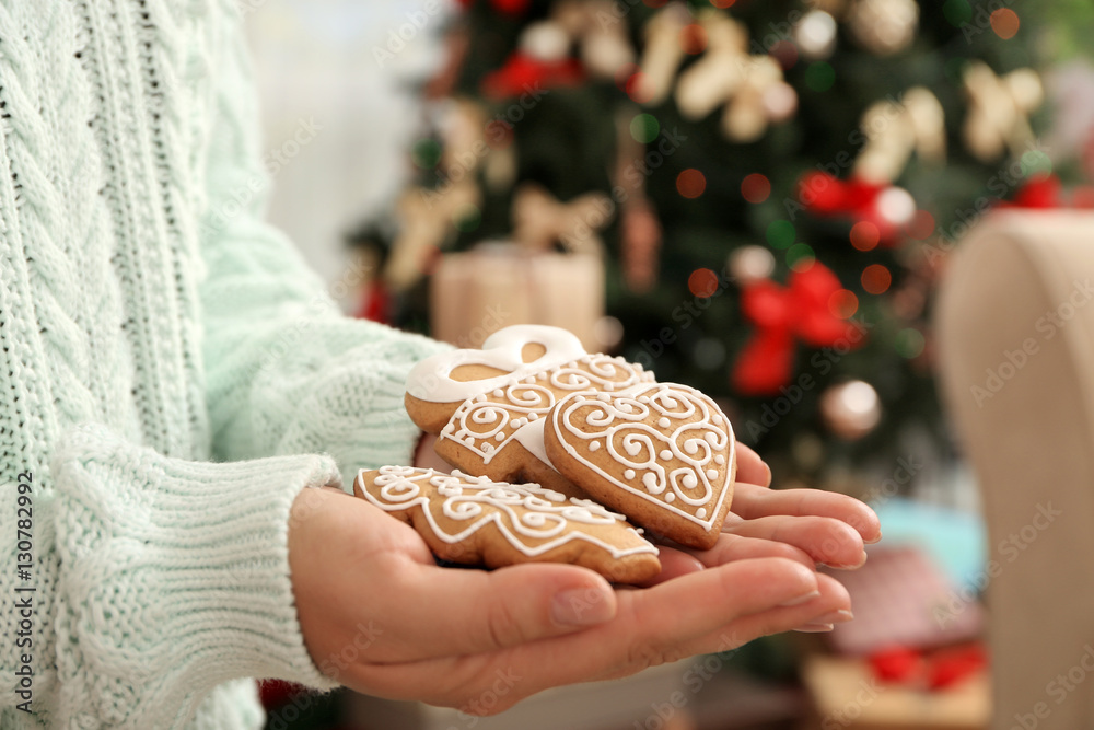 Female hands holding tasty gingerbread cookies, close up view