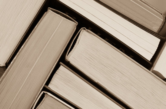 Abstract - stack of old books side view - sepia