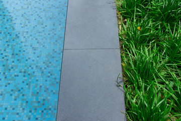 Wall Mural - Grass on the edge of the pool showing balance between nature and