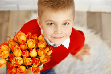 Cute boy with bouquet of beautiful flowers, close up