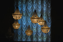 Vintage Yellow Chandeliers Hanging Next To Blue Curtain