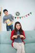 © makistock - Christmas Asian Couple. A handsome man giving her girlfriend/wif