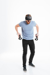 Wall Mural - Bearded young man wearing virtual reality device screaming