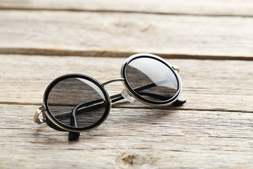 Canvas Print - Black sunglasses on a grey wooden table