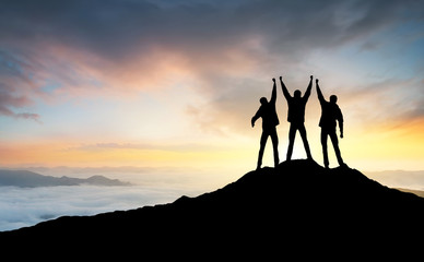 Wall Mural - silhouette of the team on the peak of mountain. sport and active life.