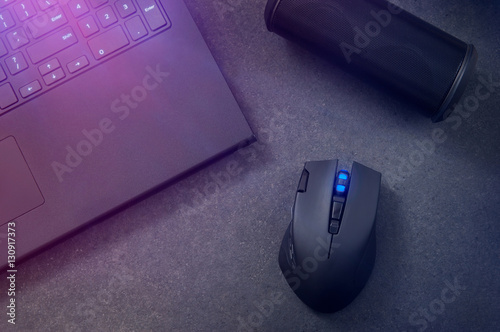 Plakat Gaming mouse, portable speaker and laptop at night.