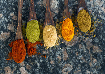 different spices in wooden spoons