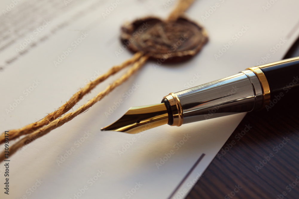Fountain pen and old notarial wax seal on document, closeup