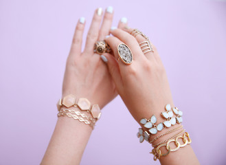 Female hands with jewelry on color background