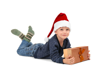 Wall Mural - Cute little boy in Santa hat with Christmas gift on white background