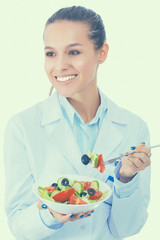 Portrait of beautiful woman doctor holding a plate with fresh vegetables.