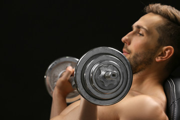 Wall Mural - Sporty man doing exercises with barbell on black background, closeup